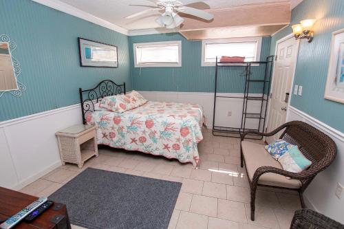 a bedroom with a bed and a chair and a fan at Oceanside, Private Pool, Hot Tub, MIL Suite, KH529, Sea Turtle Sunrise in Kitty Hawk