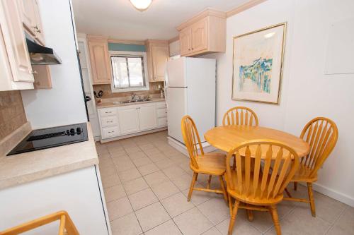 a kitchen with a table and chairs and a refrigerator at Oceanside, Private Pool, Hot Tub, MIL Suite, KH529, Sea Turtle Sunrise in Kitty Hawk