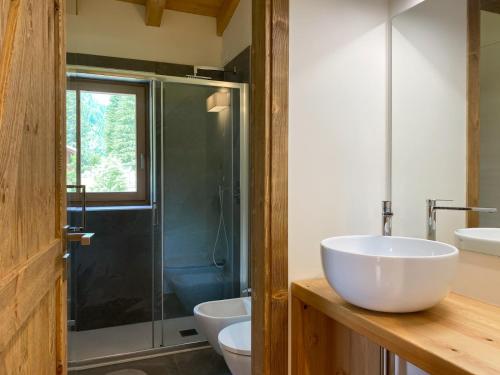 a bathroom with two sinks and a glass shower at Chalet La mia Baita in Pezzo
