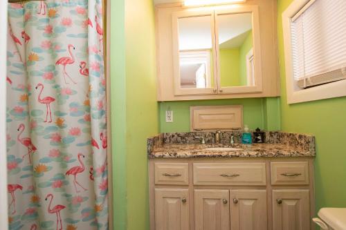 a bathroom with a sink and a shower curtain at Oceanside, Private Pool, Hot Tub, MIL Suite, KH529, Sea Turtle Sunrise in Kitty Hawk