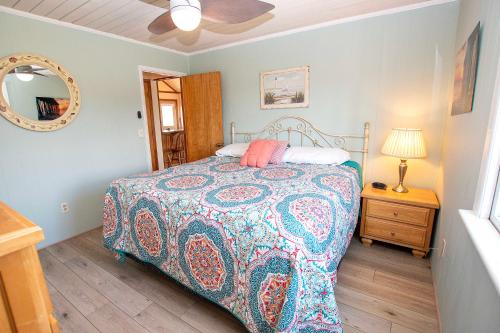 a bedroom with a bed and a lamp and a mirror at Oceanside, Private Pool, Hot Tub, MIL Suite, KH529, Sea Turtle Sunrise in Kitty Hawk