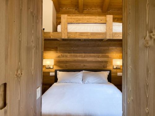 a bedroom with a bed and two bunk beds at Chalet la Mia Baita - AffittiPontediLegno in Pezzo