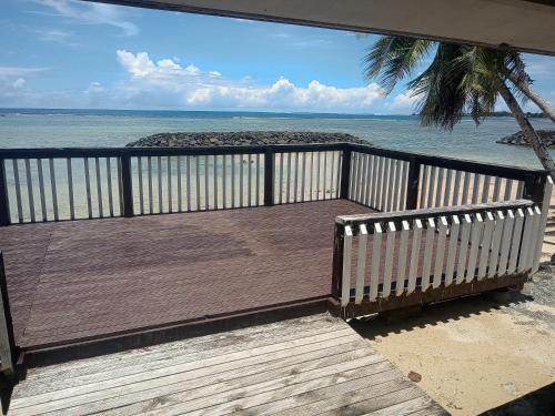 a wooden deck with a view of the ocean at Vacation beach fale in Manase