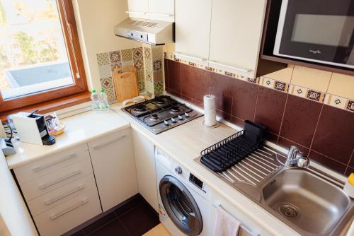 uma pequena cozinha com um fogão e uma máquina de lavar roupa em Studio @ Arena Națională Stadium em Bucareste