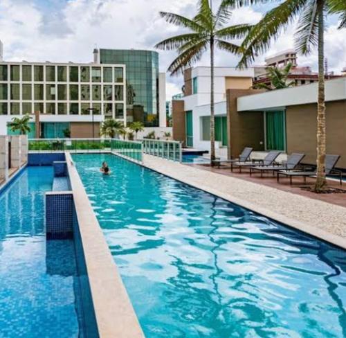a swimming pool with a person in the water at Jade Hotel BLUE Tree Brasília Flat Particular wi-fi e garagem grátis sem café in Brasília