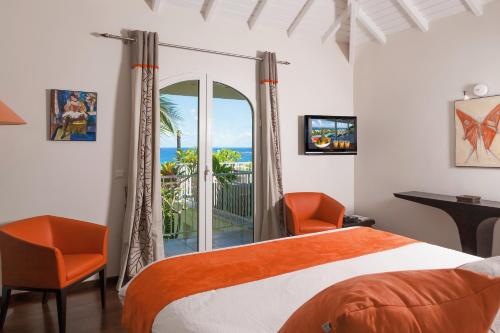 Un dormitorio con una cama y vista al mar. en Private Orient Bay Villa with Spectacular Views, en Orient Bay