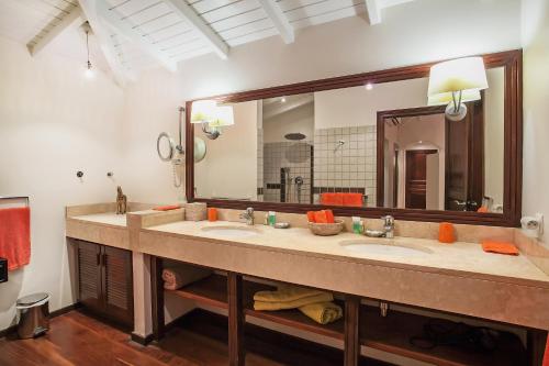 Un baño con dos lavabos y un espejo grande. en Private Orient Bay Villa with Spectacular Views, en Orient Bay
