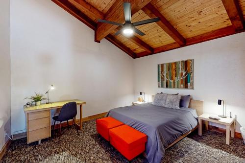 Schlafzimmer mit einem Bett, einem Schreibtisch und einem Ventilator in der Unterkunft Hilltop Lodge in Stateline