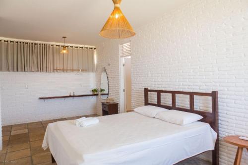 sypialnia z białym łóżkiem i lampką w obiekcie Casa Beira Mar - Piscina com Hidromassagem - Taíba w mieście São Gonçalo do Amarante