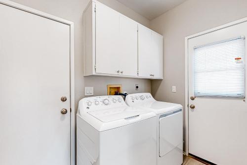 a white laundry room with a washer and dryer at Loufie's Desert Retreat in Palm Desert