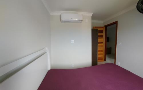 a bedroom with a purple mattress and a staircase at apartamento para até 5 pessoas in Vila Velha