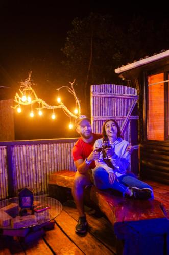 a man and woman sitting on a bench at night at Romero Glamping y Cabañas in Cali