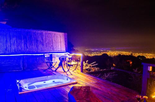 a hot tub on the deck of a building at night at Romero Glamping y Cabañas in Cali