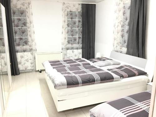 a bedroom with a bed with a black and white comforter at Ferienwohnungen Honberg in Tuttlingen