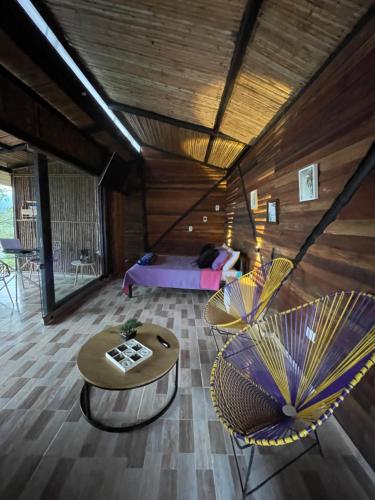 a room with two chairs and a table and a bed at Romero Glamping y Cabañas in Cali