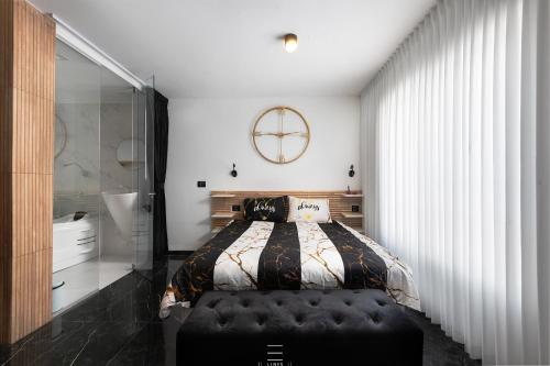 a bedroom with a bed with a black ottoman in it at מיני גן עדן עם גקוזי יש מקלט בבניין in Qiryat Motzkin
