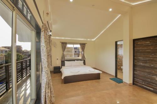 une chambre avec un lit et une grande fenêtre dans l'établissement Zomak Villa 3BHK in Lonavala with pvt pool By Bungalows In Lonavala, à Lonavala