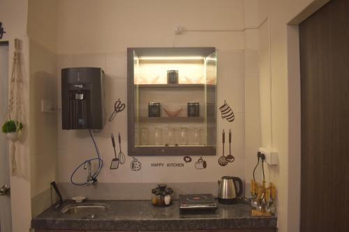 eine Küchentheke mit einem Waschbecken und einem Spiegel in der Unterkunft Mountainview Paradise in Karjat