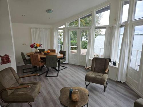 uma sala de estar com mesa e cadeiras em Chalet "Aan ut water" Elburg em Biddinghuizen