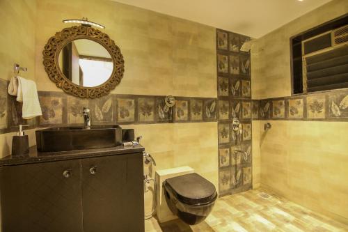 une salle de bain avec un lavabo, des toilettes et un miroir dans l'établissement Zomak Villa 3BHK in Lonavala with pvt pool By Bungalows In Lonavala, à Lonavala