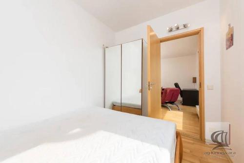 1 dormitorio con cama blanca y espejo en Cozy 2-Bedroom Penthouse in the Heart of Tallinn en Tallin