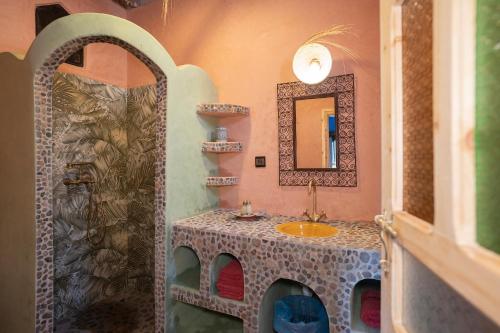 La salle de bains est pourvue d'un lavabo et d'un miroir. dans l'établissement Casa Juan, à Tagounite