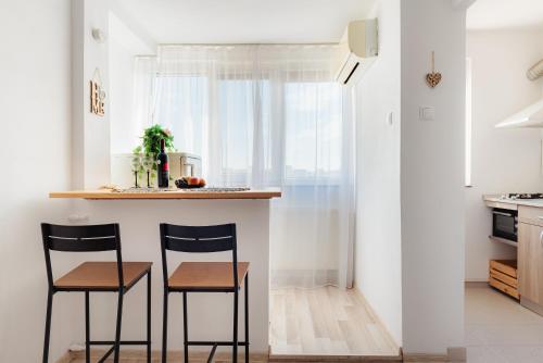a kitchen with two chairs and a counter with a window at Premium Studio next to National Arena & Park in Bucharest