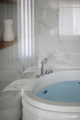 a white bathroom with a toilet and a tub at מיני גן עדן עם גקוזי יש מקלט בבניין in Qiryat Motzkin