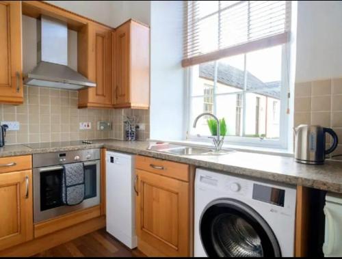 a kitchen with a washing machine and a sink at The Highland Hideout in Inverness