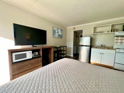 a bedroom with a bed and a flat screen tv at Atlantic Oceanside Dewey in Dewey Beach