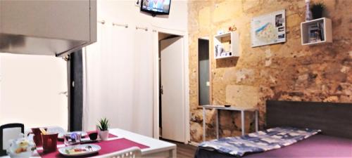 une cuisine avec un comptoir violet et une chambre avec une table dans l'établissement Studio Hypercentre Tourny, à Bordeaux