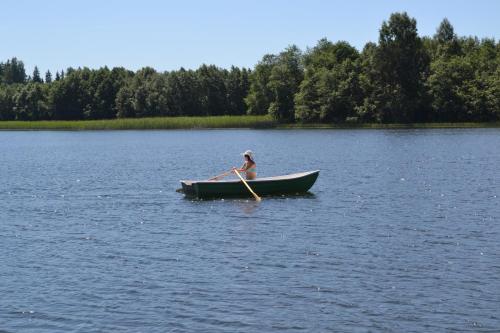 a woman is rowing a boat on a lake at Lõõdla Holiday House in Lümatu