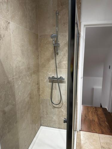 a shower with a shower head in a bathroom at Aldo's 2 Bedroom Townhouse London N1 in London