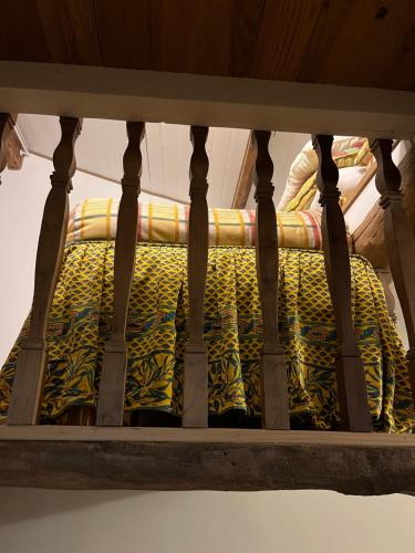a bed with a yellow and green blanket on it at Menton1974 in Menton