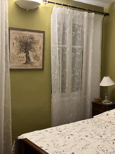 a bedroom with a bed and a picture of a tree at Menton1974 in Menton
