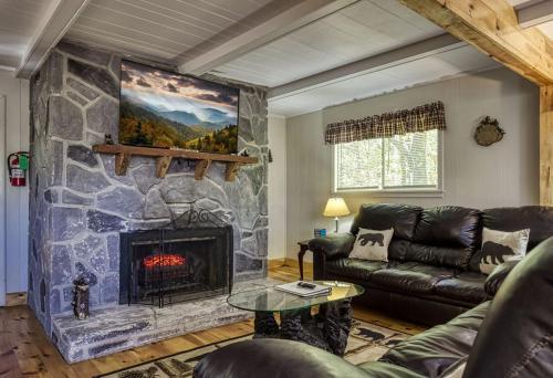 a living room with a large stone fireplace at Four Bears Den, Free Attraction Tickets, Hot Tub, Arcade Game, Gatlinburg, WIFI!!! in Gatlinburg