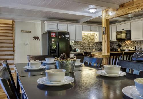 a kitchen with a table with cups and plates on it at Four Bears Den, Free Attraction Tickets, Hot Tub, Arcade Game, Gatlinburg, WIFI!!! in Gatlinburg