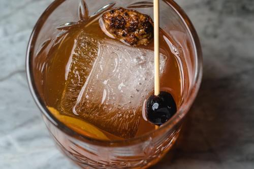 a glass of iced tea with a cookie on top at The Burgess Hotel, Atlanta, a Tribute Portfolio Hotel in Atlanta