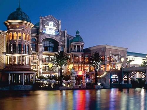 a large building with palm trees in front of it at Majorca Self-Catering Apartments in Cape Town