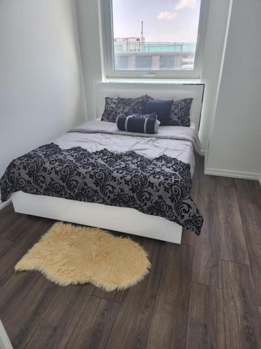 a bedroom with a bed with a rug and a window at Aethestic Apartment 2bedroom unit in Vaughan