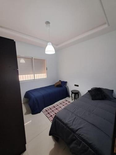 1 Schlafzimmer mit 2 Betten in einem weißen Zimmer in der Unterkunft Apartamento moderno Aparcamiento gratis in Tétouan