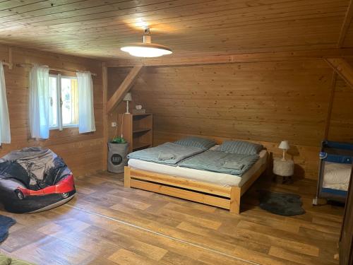 1 dormitorio con 1 cama en una cabaña de madera en Romantická chalupa Timka, en Dolni Dvur