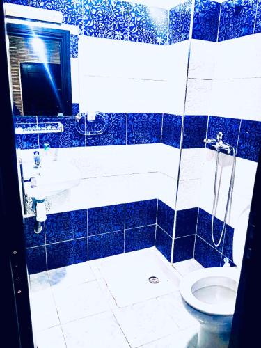 y baño azul y blanco con ducha y aseo. en Appartement luxueux Centre Agadir en Agadir