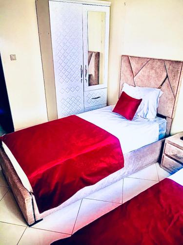 um quarto com uma cama grande e um cobertor vermelho em Appartement luxueux Centre Agadir em Agadir