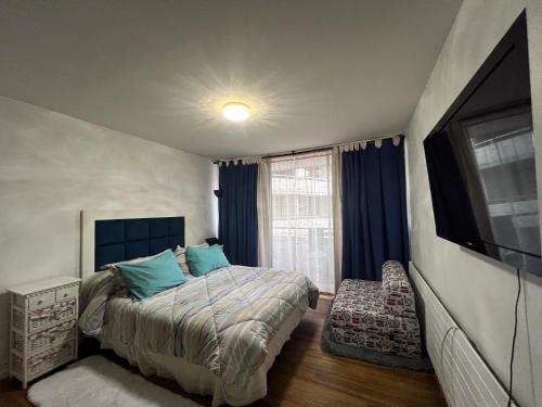 1 dormitorio con 1 cama y TV de pantalla plana en Departamentos Providencia J&M, en Santiago