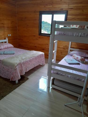 a bedroom with two bunk beds and a window at casa dos sonhos in Bom Jardim da Serra