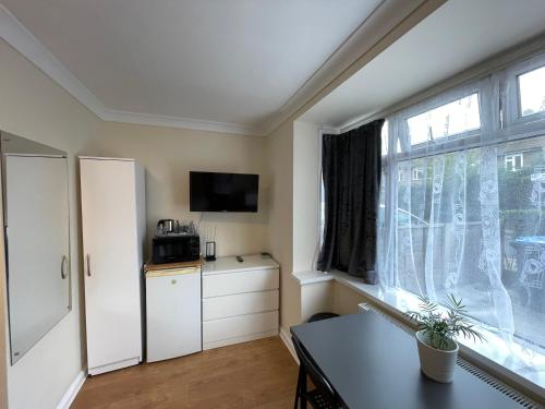 a living room with a table and a window at Kensal Lodge Guest House in London