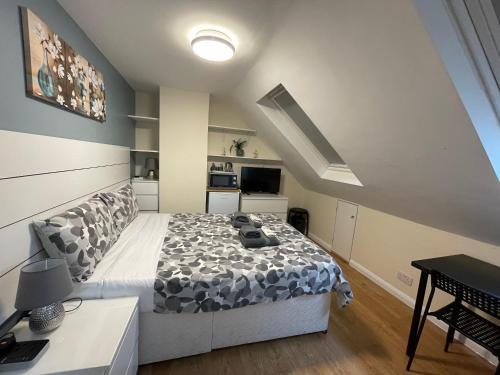 1 dormitorio con 1 cama grande y TV en Kensal Lodge Guest House, en Londres