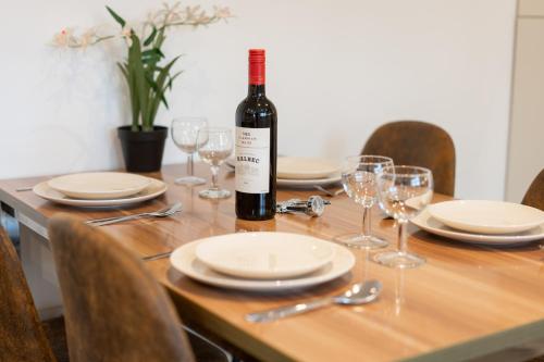 a bottle of wine sitting on a table with glasses at Cosy Modern City Centre 2 Bed Apartment in Belfast