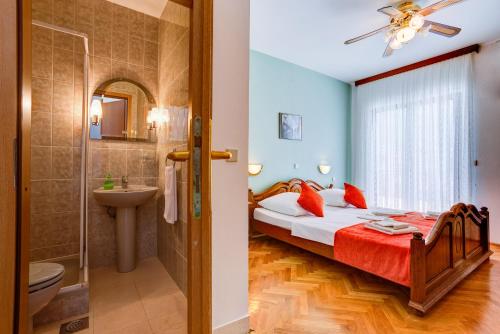 a bedroom with a bed and a bathroom at Bed & Breakfast Senator in Podstrana